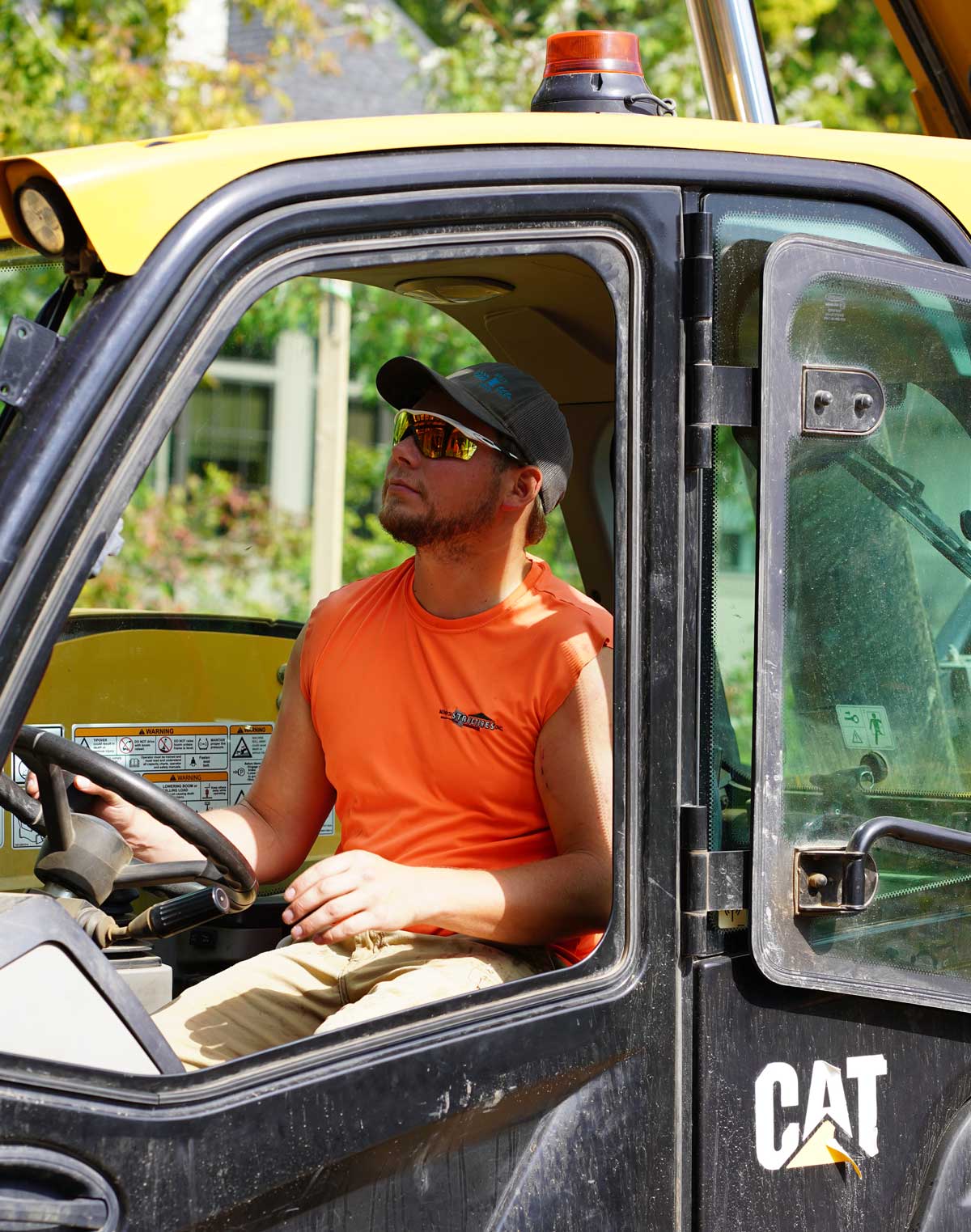Construction worker operating a CAT excavator at a Minnesota Structures job site.