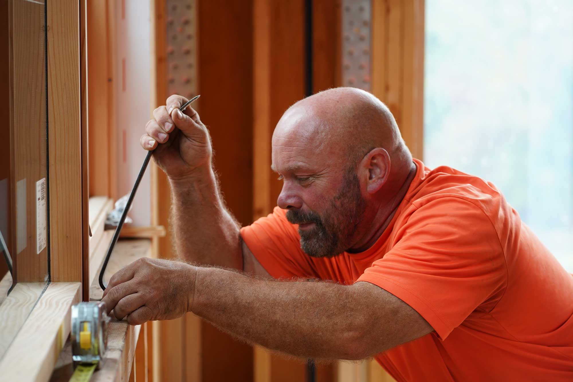 Minnesota Structures carpenter measuring wood framing during residential construction