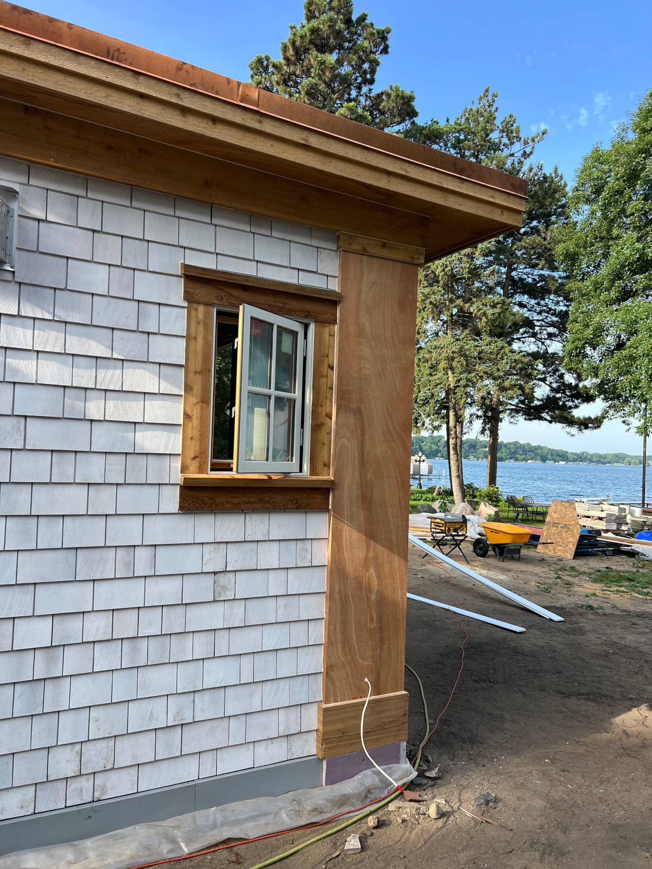 Small building with cedar trim and shingle siding overlooking a lake, Minnesota Structures project