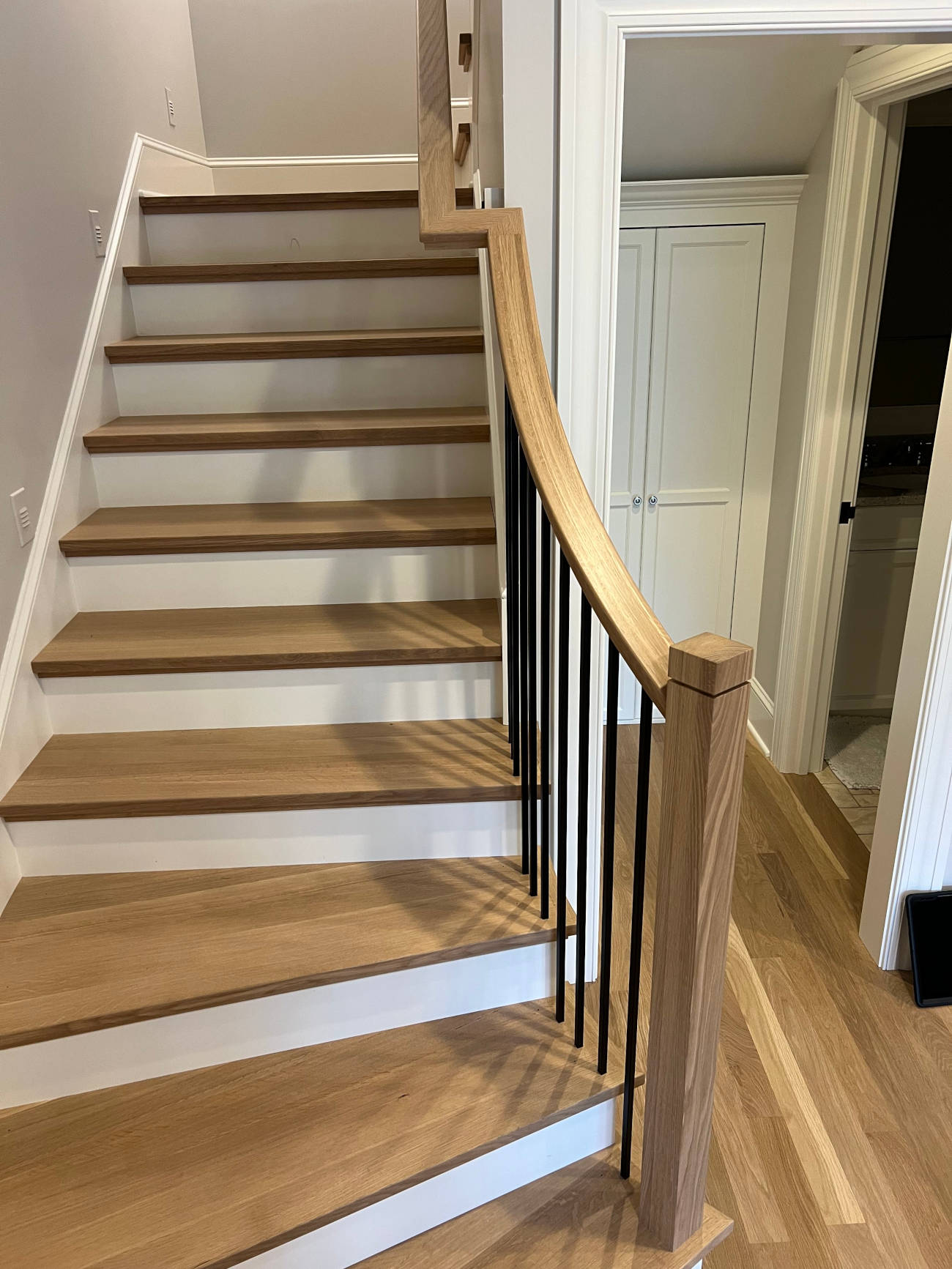 Custom wood staircase with black iron railings installed in residential home