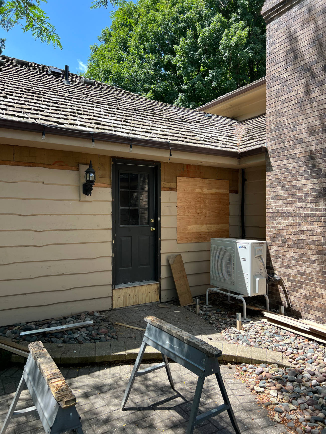 Home exterior renovation with boarded windows and new siding installation