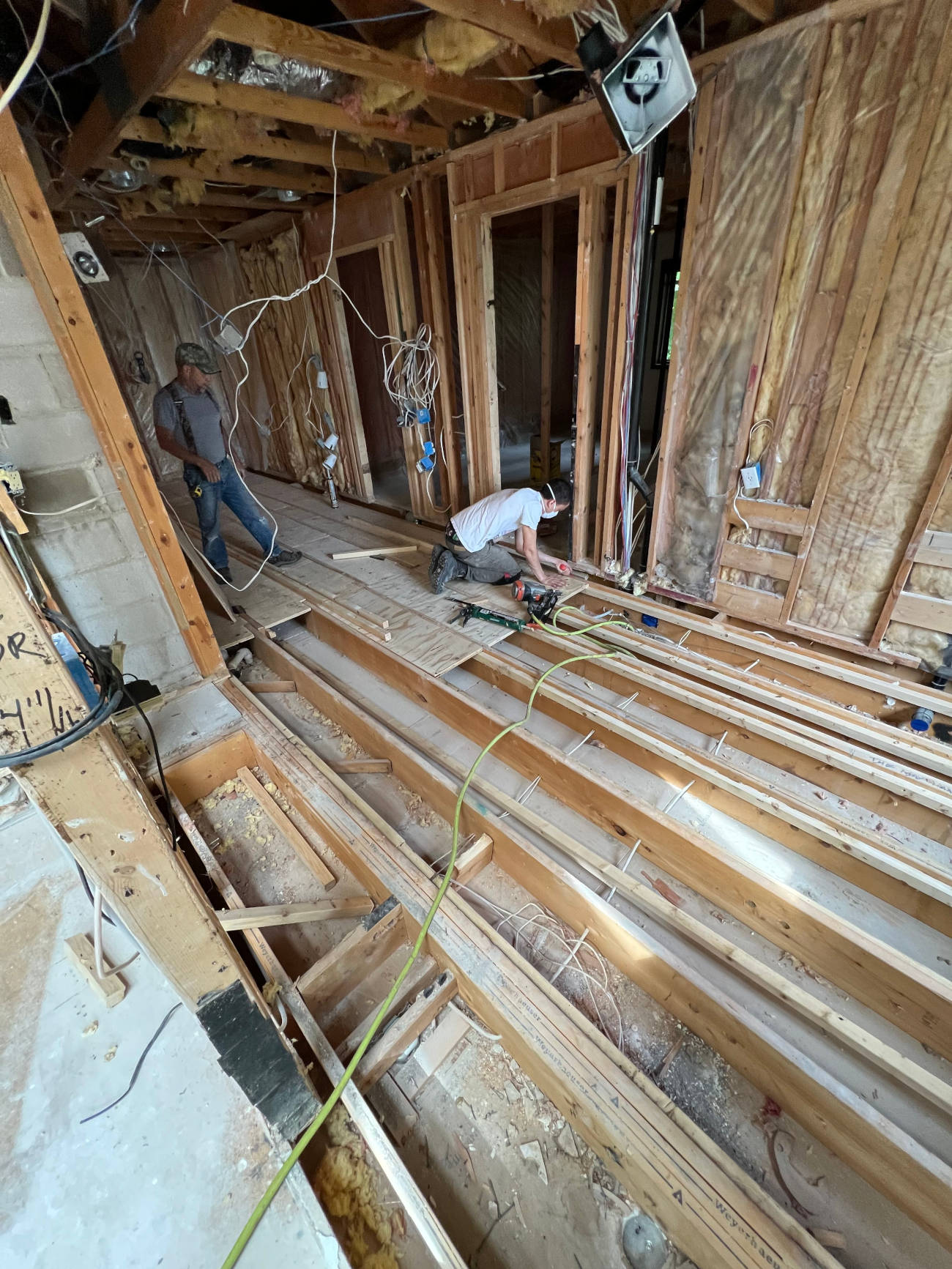 Minnesota Structures carpenters installing new floor joists and framing during a home remodel.