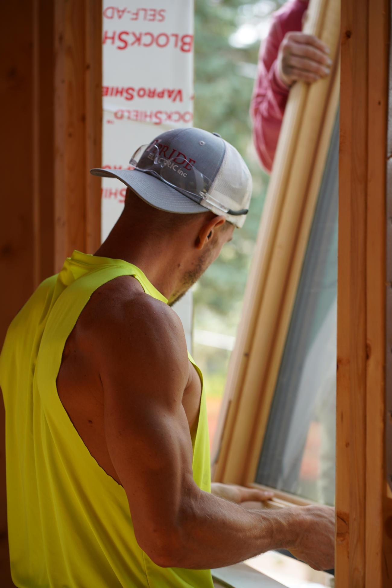 Construction worker installing a window frame inside a home remodel